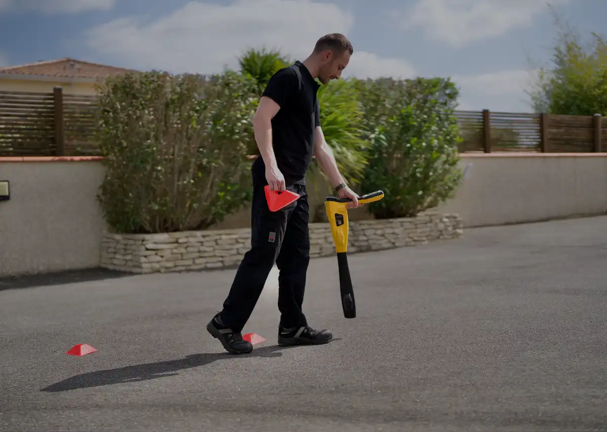 a man holding a shovel and a red cone
