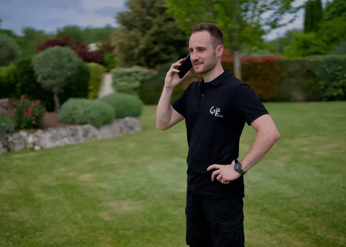 a man in a black shirt talking on a cell phone